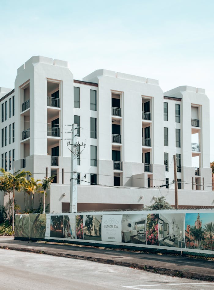 Crafting Captivating Headlines: Your awesome post title goes here Elegant modern apartment building exterior in Coral Gables, Florida, under a clear blue sky.
